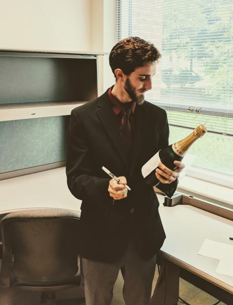 Aaron Calvin prepares to sign his celebratory champagne bottle